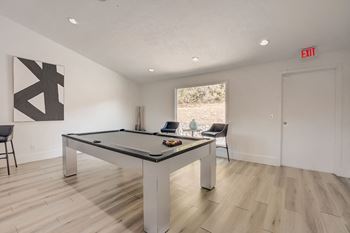 a game room with a pool table and a exit sign